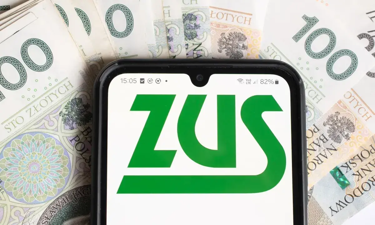 Telefon z logo ZUS na tle banknotów 100 zł. Symbolizuje to przyszłość i emeryturę socjalną.