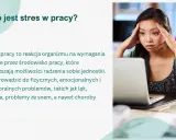 Kobieta z dłońmi na skroniach, wyraźnie odczuwająca stres w pracy. Obok laptop i kubek.