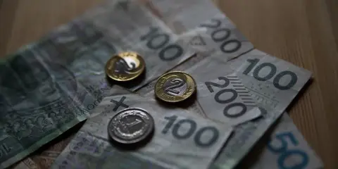 Polskie banknoty i monety. Czy umowa zlecenie wlicza się do emerytury? Pieniądze na stole.