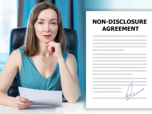 Kobieta w biurze trzyma dokument NDA. Obok widnieje podpisany dokument o poufności.
