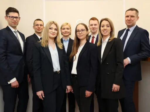 Grupa prawników w garniturach pozuje do zdjęcia.
