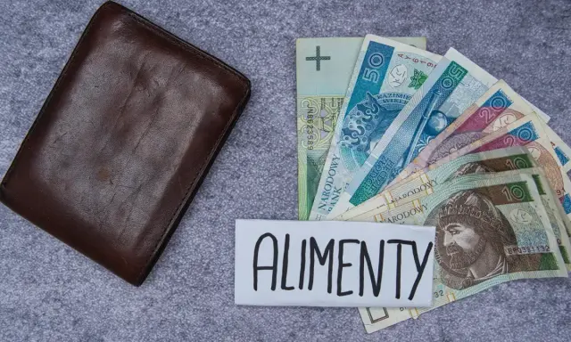 Brązowy portfel obok polskich banknotów i napisu "ALIMENTY". Symbolizuje wsparcie finansowe dla dzieci.