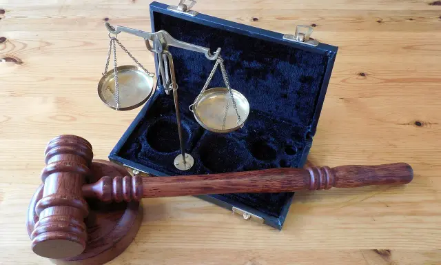 Młotek sędziowski i waga szalkowa w futerale. Symbol sprawiedliwości i prawa, gotowe do wydania wyroku w sprawie 288 kk.