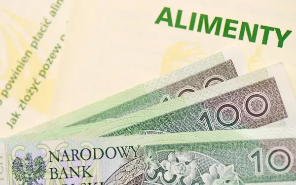 Złotówki i dokument z napisem "ALIMENTY" przypominają o obowiązku alimentacyjnym.